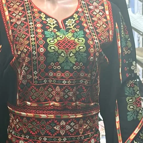 Red and green tatreez on a black dress in Amman