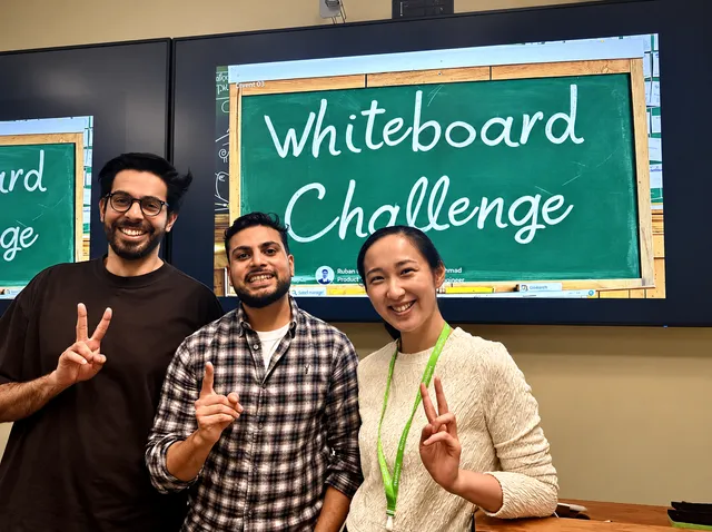 In front of the Whiteboard Challenge chalkboard